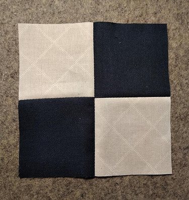Four squares of fabric sewn together to form a four-patch quilt block