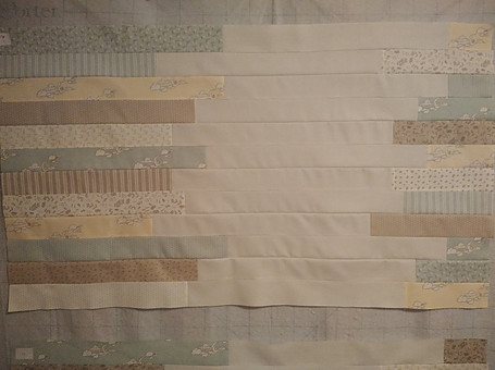 FAbric strips sewn together and placed on a design wall to check placement before sewing last section