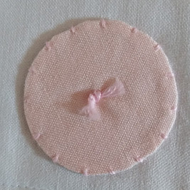 Round applique on baby quilt in pink fabric