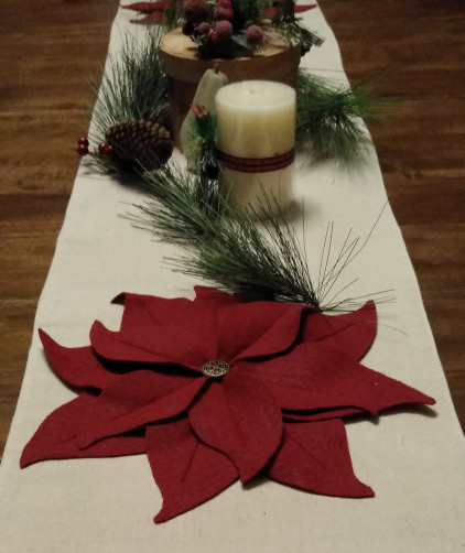 Table runner with Christmas poinsettia, greenery, candle and decorated wooden box