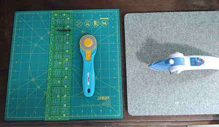 12' square rotating cutting mat, 45 rotary cutter, 2.5' x 12.5' ruler and Dritz mini iron on gray wool pressing mat