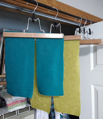 Starched blue and green fabrics hanging to dry