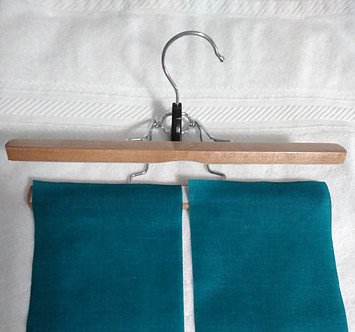 Starched blue fabric positioned to hang on trouser hanger to dry