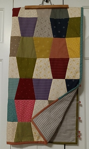 Multi-colored quilt top pieced using the tumbler template