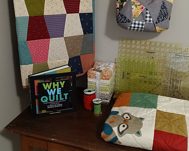 Sewing table with fabric, quilts, book and notions