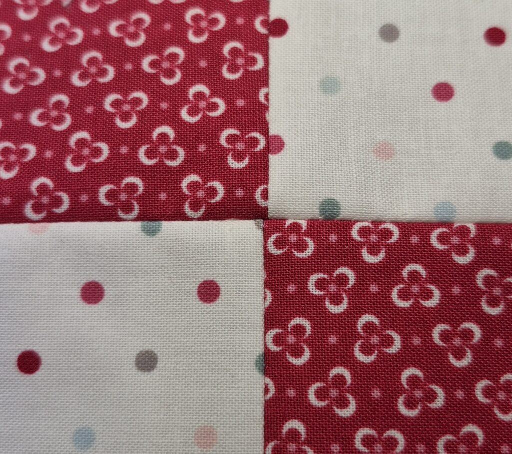 Top side of 4 square patch showing seams meeting at center point.