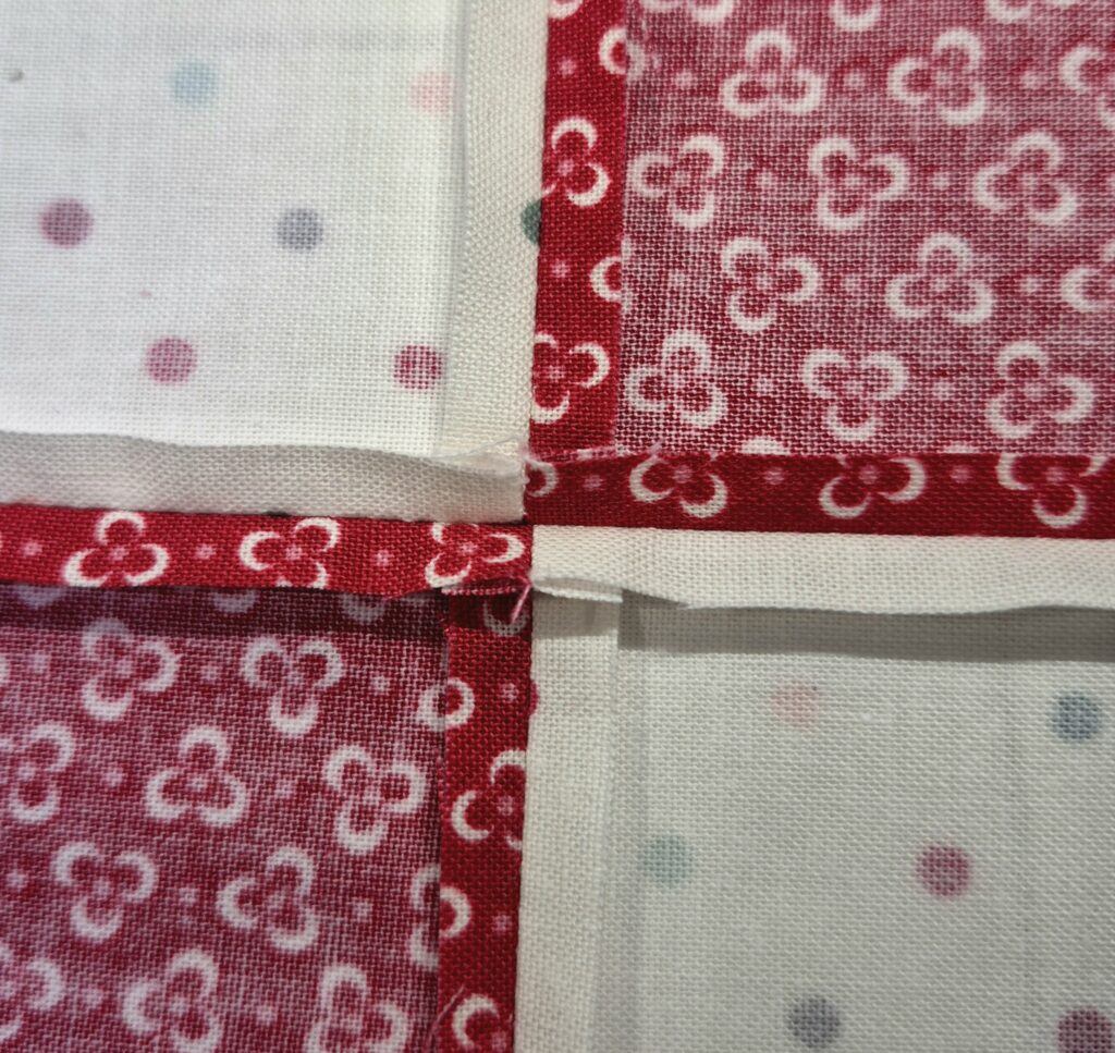 Backside of 4 square patch showing how seams nest to meet at a center point.