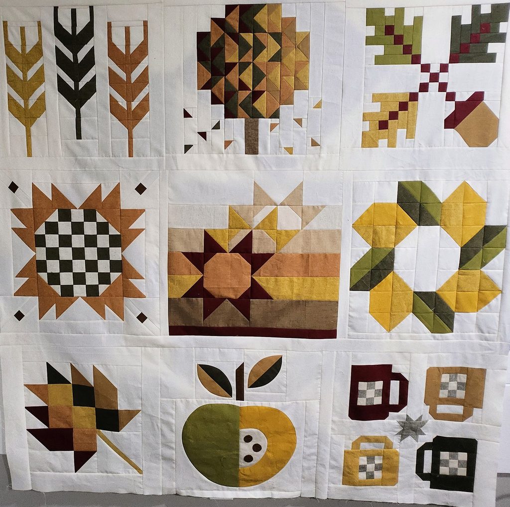Quilt top made from Sweater Weather 2024 quilt blocks. Fabrics in autumnal colors in Essex linen by Robert Kauffman